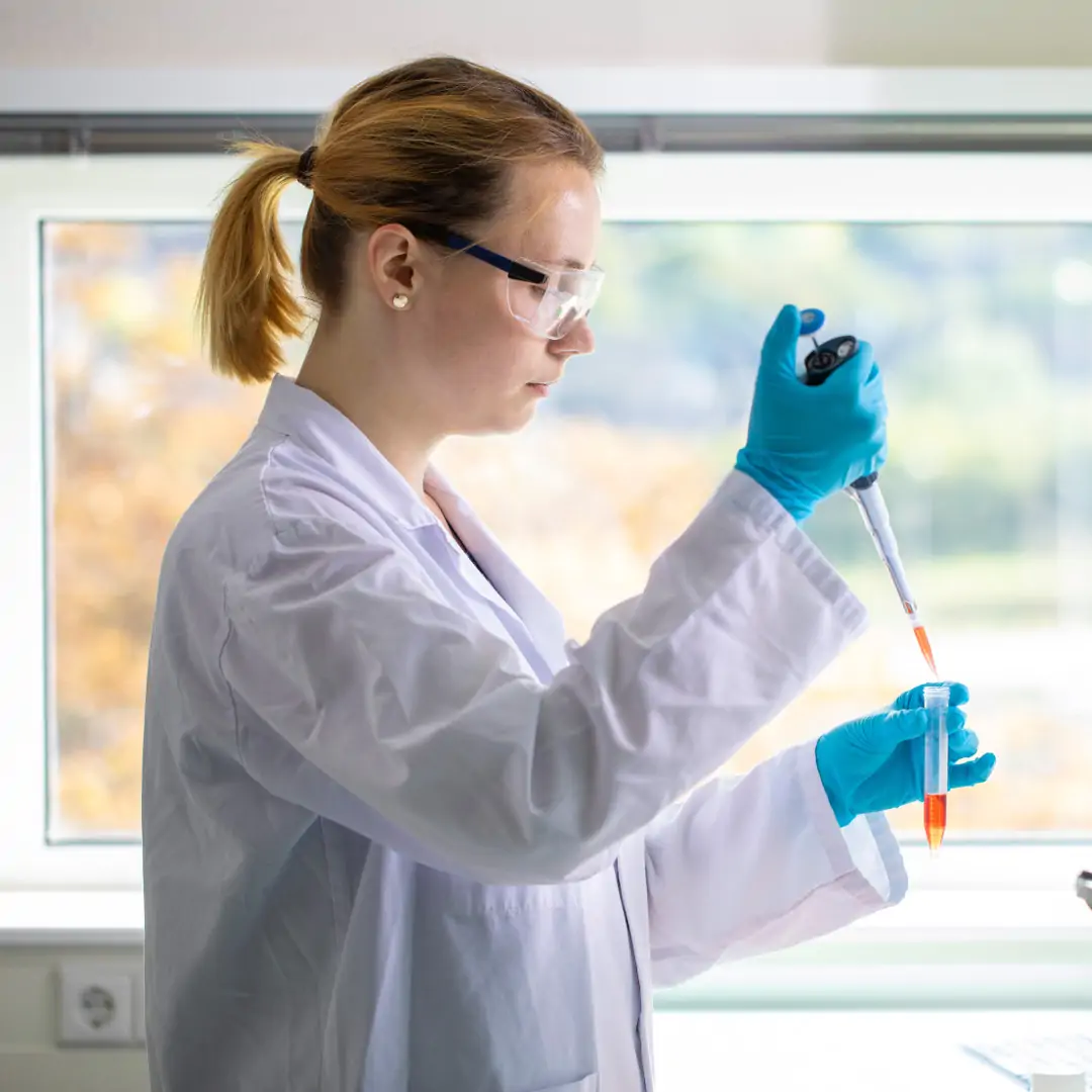 Women filling vial in lab